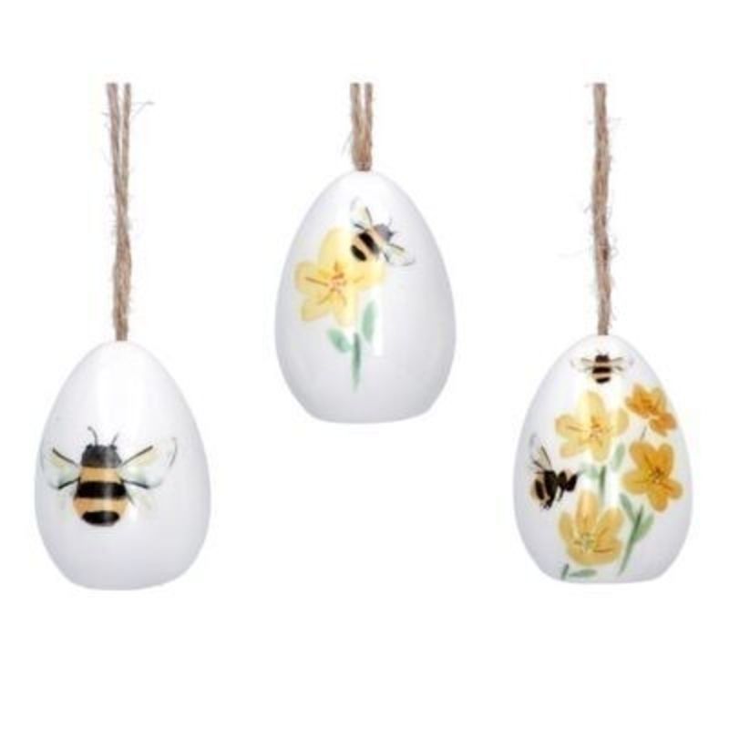 White ceramic egg shaped hanging decoration with bee and buttercup detail. The perfect addition to your home for Easter and Spring. 3 designs. By Gisela Graham.